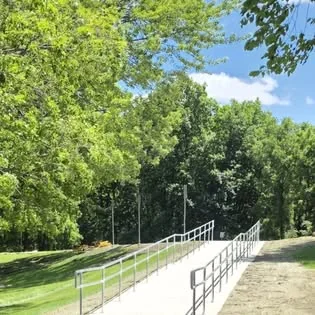 A long silver steel railing running beside an outdoor ramp